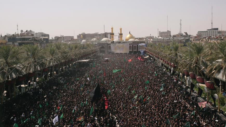 Iraqi Shi'ite pilgrims run between the Imam Hussein and Imam Abbas shrines as part of a ritual of the Ashura ceremony in Karbala, Iraq September 20, 2018. REUTERS/Abdullah Dhiaa Al-Deen - RC1A6C155200