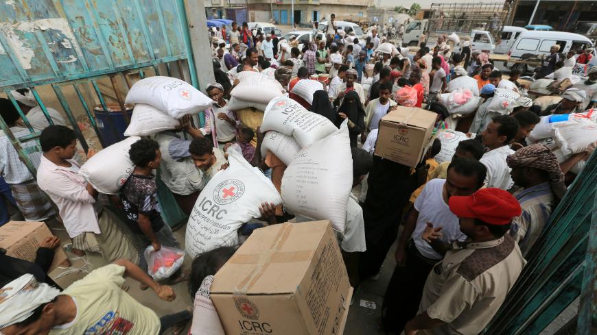 People carry food aid delivered by the International Committee of the Red Cross to internally displaced people in the Red Sea port city of Hodeidah, Yemen, July 21, 2018. REUTERS/Abduljabbar Zeyad - RC1233D23F30