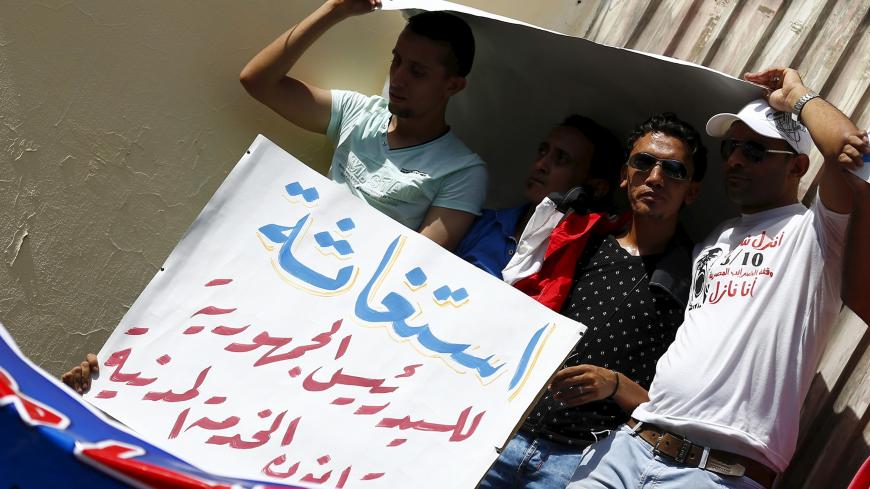 Staff and workers of Egypt's Ministry of Finance Tax Authority hold a sign which reads, "Distress to President of the Republic, Cancel the Civil Service Law" during a protest in front of the Syndicate of Journalists in Cairo, August 10, 2015. Trade union workers staged the protest to demand the abolition of the Civil Service Law and a minimum and a maximum wage for public servants, local media reported.  REUTERS/Amr Abdallah Dalsh - GF20000019148