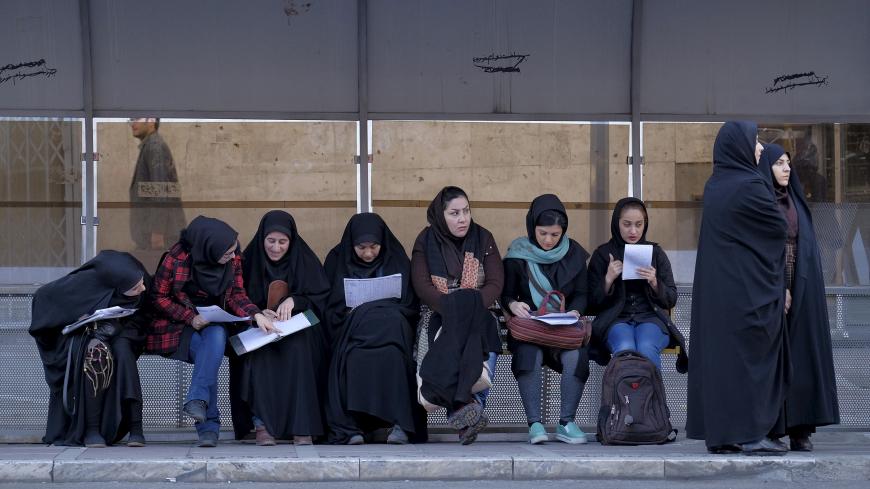 Iranian students study as they wait for a bus in central Tehran January 16, 2016. REUTERS/Raheb Homavandi/TIMA  ATTENTION EDITORS - THIS IMAGE WAS PROVIDED BY A THIRD PARTY. FOR EDITORIAL USE ONLY.   - GF20000096751