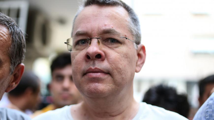 US pastor Andrew Craig Brunson escorted by Turkish plain clothes police officers arrives at his house on July 25, 2018 in Izmir. - Turkey on July 15, 2018 moved from jail to house arrest US pastor Andrew Brunson who has spent almost two years imprisoned on terror-related charges, in a controversial case that has ratcheted up tensions with the United States. Andrew Brunson, who ran a protestant church in the Aegean city of Izmir, was first detained in October 2016 and had remained in prison in Turkey ever si