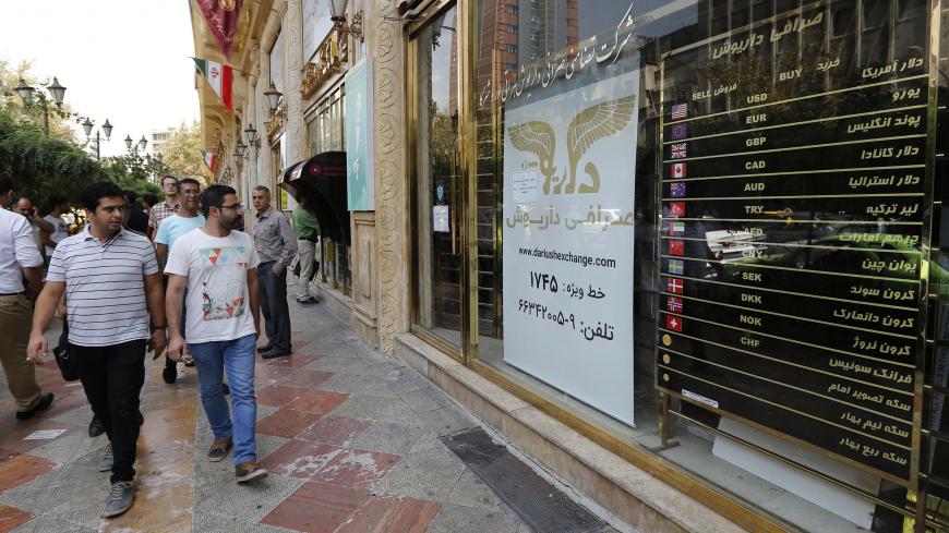 People walk in front of a currency exchange shop in the Iranian capital Tehran on August 8, 2018. - US President Donald Trump warned the world the previous day against doing business with Iran as Washington reimposed "the most biting sanctions ever" on the Islamic republic, triggering a mix of anger, fear and defiance in Tehran. (Photo by ATTA KENARE / AFP)        (Photo credit should read ATTA KENARE/AFP/Getty Images)