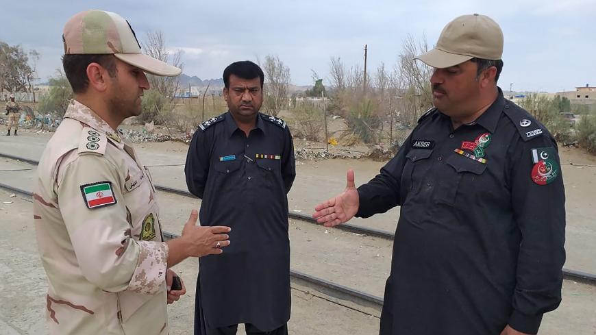 In this photo taken on October 16, 2018, a Pakistani border security official (R) and an Iranian border official meet at Zero Point in the Pakistan-Iran border town of Taftan. - At least 11 Iranian security personnel, including Revolutionary Guards intelligence officers, were abducted on the southeastern border with Pakistan on October 16, state media reported. State news agency IRNA said 14 troops were seized, while local media and other sources gave the number as 11. (Photo by - / AFP)        (Photo credi