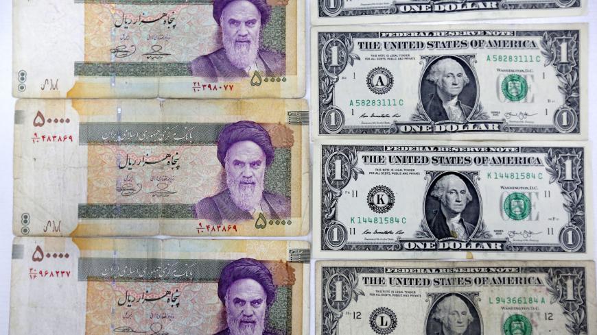 A close up shot shows Iran's various Rial banknotes, bearing a portrait of Iran's late founder of Islamic Republic Ayatollah Ruhollah Khomeini, next to United States one-Dollar bills bearing a portrait of first US President, George Washington in Tehran on April 10, 2018. - Iran took the drastic step of fixing the rate of its currency against the dollar in a bid to arrest a slide that has seen it fall by a third in six months. (Photo by ATTA KENARE / AFP)        (Photo credit should read ATTA KENARE/AFP/Gett