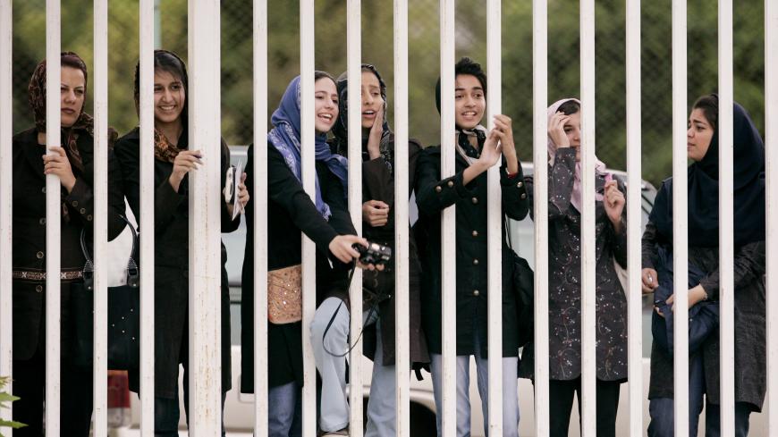 Iranian women watch the practice session of Iran's national soccer team from behind the railings as they banned from entering the stadium at Azadi (freedom) sport complex in Tehran, Iran May 21, 2006.  WORLD CUP 2006 PREVIEW     REUTERS/Morteza Nikoubazl - GM1DSQRUFHAA