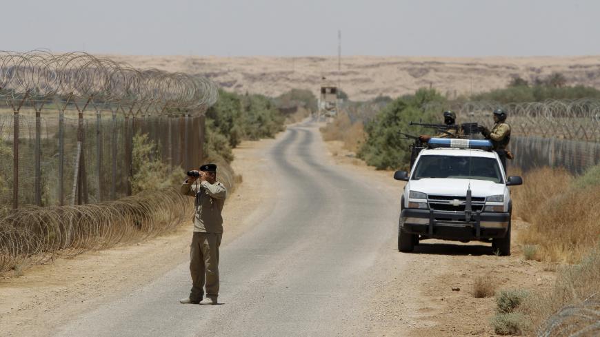 An Iraqi soldier looks through a pair of binoculars near the Iraqi-Syrian borders at the Abu Kamal-qaim border crossing, the main border post between Iraq and Syria, July 20, 2012. REUTERS/Saad Shalash (IRAQ - Tags: CIVIL UNREST MILITARY) - GM1E87K1QAO01