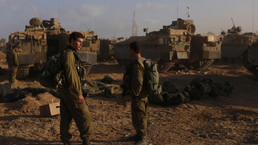 Israeli soldiers stand at a staging area near the border with the Gaza Strip July 31, 2014. Israel pressed ahead with its Gaza offensive saying it was days from achieving its core goal of destroying all Islamist guerrilla cross-border attack tunnels, but a soaring Palestinian civilian toll has triggered international alarm. REUTERS/Siegfried Modola (ISRAEL - Tags: CIVIL UNREST MILITARY POLITICS CONFLICT) - GM1EA7V16RK01
