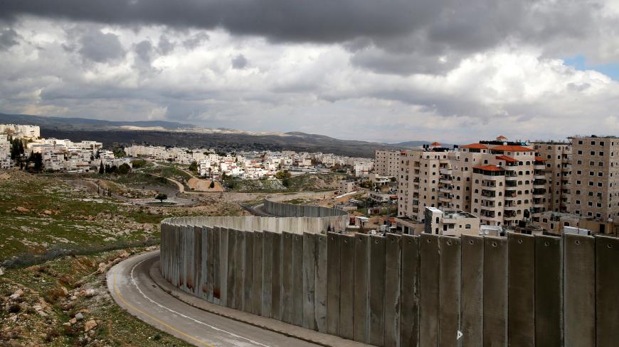 A general view picture shows the Israeli barrier running between the East Jerusalem refugee camp of Shuafat (R) and Pisgat Zeev, both located in an area Israel annexed to Jerusalem after capturing it in the 1967 Middle East war February 15, 2017. REUTERS/Ammar Awad - RC1A1A450A60