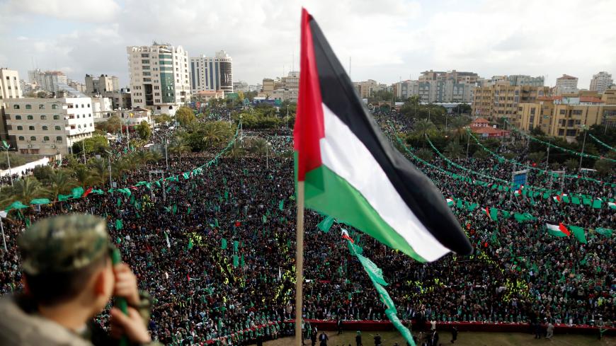 A Palestinian flag is seen as Hamas supporters take part in a rally marking the 30th anniversary of Hamas' founding, in Gaza City December 14, 2017. REUTERS/Suhaib Salem - RC126F8FA600