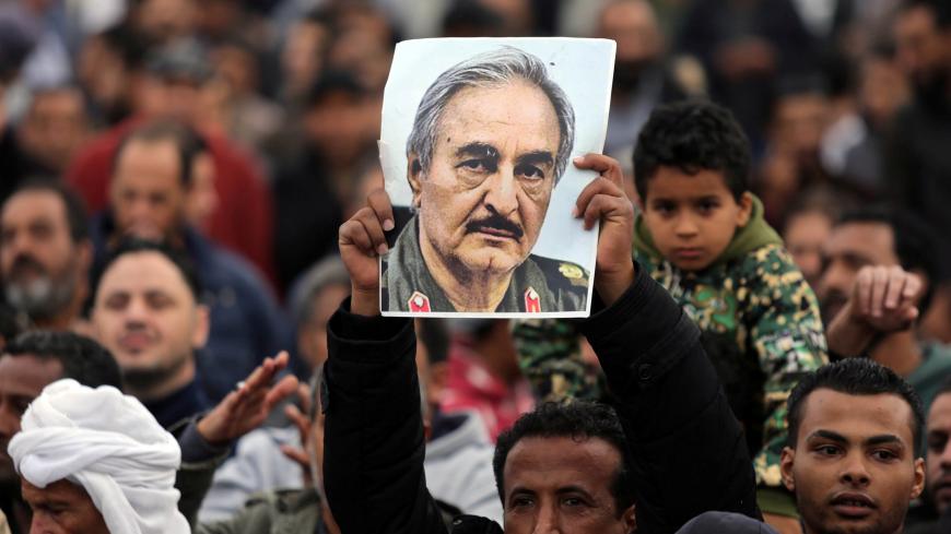 A man holds a poster of Eastern Libyan military commander Khalifa Haftar during a rally demanding Haftar to take over, after a U.N. deal for a political solution missed what his supporters said was a self-imposed deadline on Sunday, in Benghazi, Libya, December 17, 2017. REUTERS/Esam Omran Al-Fetori - RC1E8C45E420