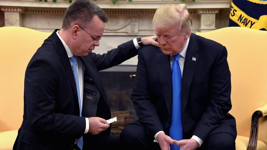 U.S. President Donald Trump closes his eyes in prayer along with Pastor Andrew Brunson, after his release from two years of Turkish detention, in the Oval Office of the White House, Washington, U.S., October 13, 2018. REUTERS/Mike Theiler     TPX IMAGES OF THE DAY - RC18ECD30AF0