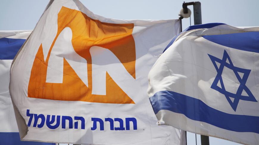 The logo of Israel Electric Corp is seen on a flag next to the Israeli national flag at a power station in the coastal city of Hadera May 19, 2012. Israel Electric Corp (IEC), which is responsible for nearly every aspect of electricity from running power plants to connecting households, simply cannot keep up with growing demand.The state-owned utility just lost natural gas supplies from neighbouring Egypt and fuel costs are soaring. Reserves are low and capacity insufficient and the government, under pressu
