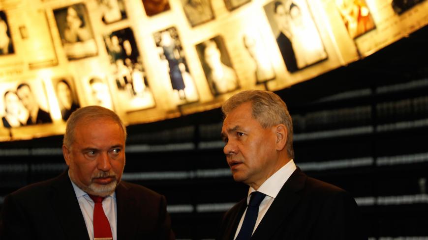 Russian Defence Minister Sergey Shoigu (R) stands next to his Israeli counterpart Avigdor Lieberman as as they look at pictures of Jews killed in the Holocaust during a visit to the Hall of Names at Yad Vashem's Holocaust History Museum in Jerusalem October 17, 2017. REUTERS/Ronen Zvulun - RC1504C794D0