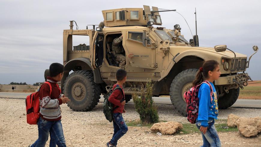 Syrian schoolchildren walk as U.S. troops patrol near Turkish border in Hasakah, Syria November 4, 2018. REUTERS/Rodi Said - RC11C2532E70