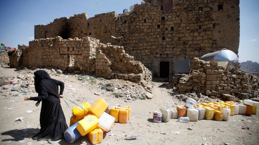 A woman displaced from the Red Sea port city of Hodeidah pulls empty canisters outside her family shelter in Sanaa, Yemen November 2, 2018. Picture taken November 2, 2018. REUTERS/Mohamed al-Sayaghi - RC1DA98E70A0