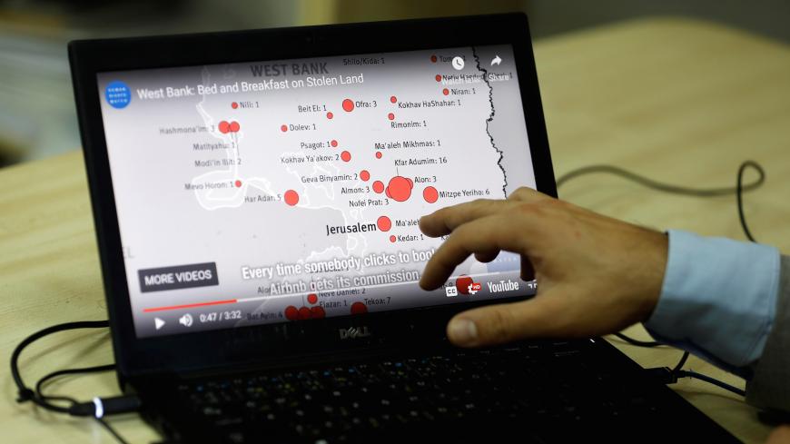 Omar Shakir, Israel and Palestine Director at Human Rights Watch, shows a map during an interview on home-renting company Airbnb's decision to remove listings in Israeli settlements, in Ramallah,  in the occupied West Bank, November 20, 2018. REUTERS/Mohamad Torokman - RC17C73791A0