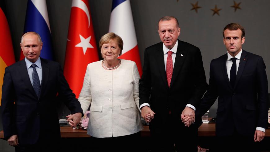 German Chancellor Angela Merkel, Russian President Vladimir Putin, Turkish President Tayyip Erdogan and French President Emmanuel Macron hold hands at a news conference after a Syria summit, in Istanbul, Turkey October 27, 2018. REUTERS/Murad Sezer - RC16134E6CB0