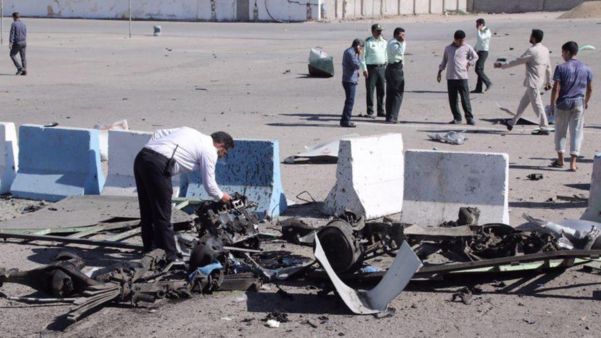 A policeman inspects the wreckage of a car bomb which exploded in front of a police station in the city of Chabahar, on December 06, 2018 in southern Iran. - A suicide bomber killed at least two people outside the police headquarters in the port city of Chabahar in restive southeastern Iran, according to a revised official toll. (Photo by STR / TASNIM NEWS / AFP)        (Photo credit should read STR/AFP/Getty Images)