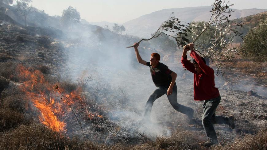 Palestinians extinguish fire at an olive tree grove that was allegedly set ablaze by Jewish settlers in the northern West Bank village of Salem, east of Nablus, on November 14, 2010. AFP PHOTOJAAFAR ASHTIYEH        (Photo credit should read JAAFAR ASHTIYEH/AFP/Getty Images)
