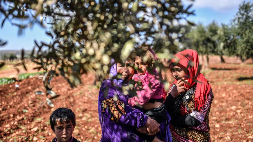 Syrian people look on behind an olive tree branch as they arrive at a check point in the village of Anab ahead of crossing to the Turkish-backed Syrian rebels side on March 17, 2018, as civilians flee the city of Afrin in northern Syria.
More than 200,000 civilians have fled the city of Afrin in northern Syria in less than three days to escape a Turkish-led military offensive against a Kurdish militia, the Syrian Observatory for Human Rights said. / AFP PHOTO / BULENT KILIC        (Photo credit should read 