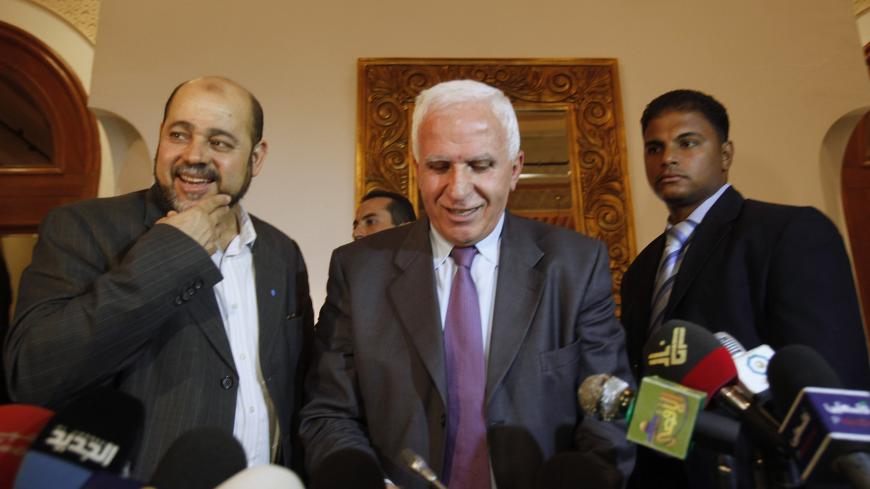 Azzam al-Ahmad (L), head of the Fatah group, and Mousa Abu Marzook (C), a senior member of Hamas, speak after a news conference in Cairo April 27, 2011. Palestinian President Mahmoud Abbas's Fatah group has inked a deal with bitter rival Hamas to end their long-running feud and form an interim government ahead of elections this year, officials said on Wednesday.    REUTERS/Asmaa Waguih (EGYPT - Tags: POLITICS) - GM1E74S0BG101