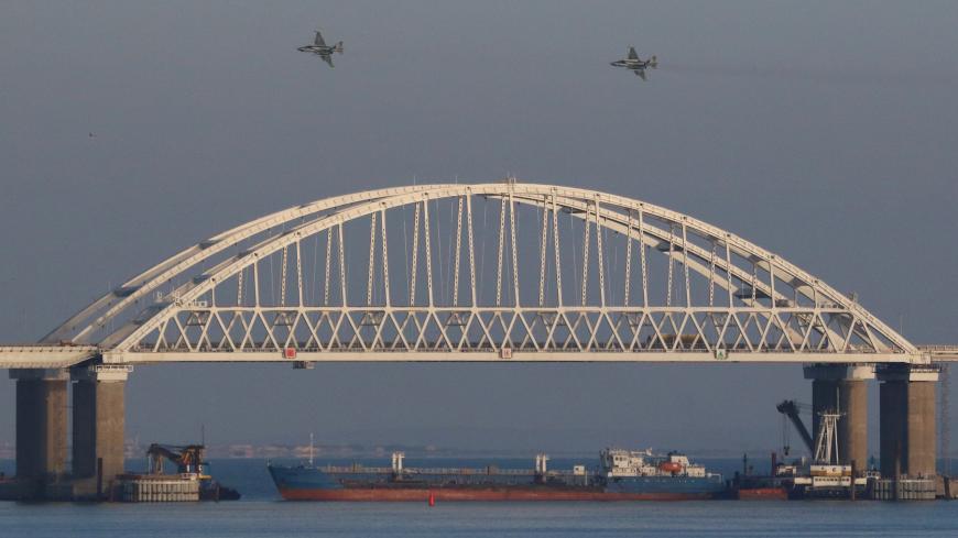 Russian jet fighters fly over a bridge connecting the Russian mainland with the Crimean Peninsula with a cargo ship beneath it after three Ukrainian navy vessels were stopped by Russia from entering the Sea of Azov via the Kerch Strait in the Black Sea, Crimea November 25, 2018. REUTERS/Pavel Rebrov - UP1EEBP150TU1