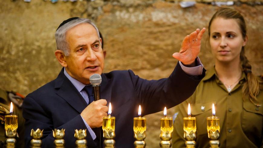 Israeli Prime Minister Benjamin Netanyahu speaks during a candle lightning ceremony on the Jewish holiday of Hanukkah at the Western Wall in Jerusalem's Old City December 6, 2018 Gil Cohen Magen/Pool via REUTERS - RC194FC2E670