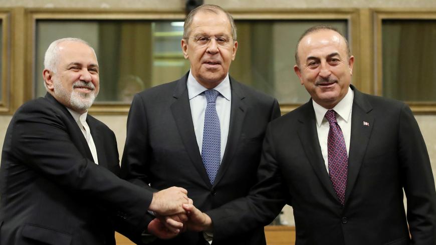 Russian Foreign Minister Sergei Lavrov, Turkish Foreign Minister Mevlut Cavusoglu and Iranian Foreign Minister Mohammad Javad Zarif shake hands as they attend a news conference after talks on forming a constitutional committee in Syria, at the United Nations in Geneva, Switzerland, December 18, 2018. REUTERS/Denis Balibouse - RC1C28C75F90