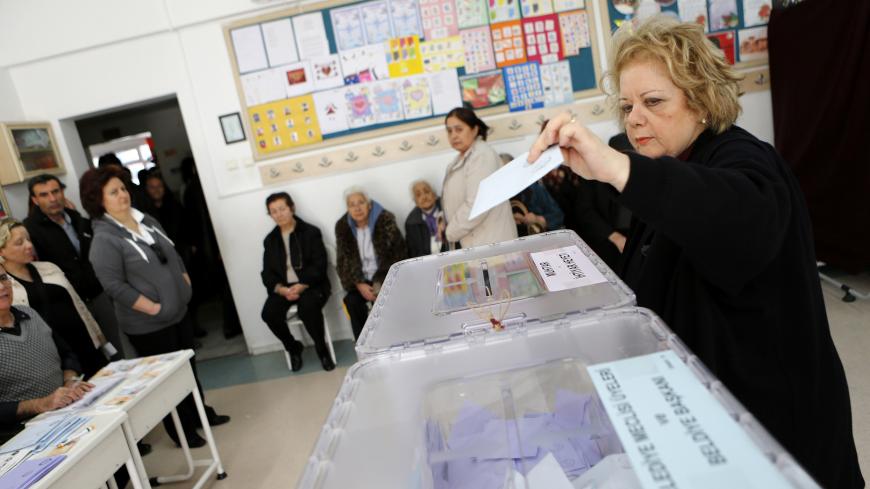 A woman casts her vote as others wait in line at a polling station in Ankara March 30, 2014.  Prime Minister Tayyip Erdogan looks set to win Sunday's municipal elections that have become a crisis referendum on his 10-year rule as he tries to ward off graft allegations and stem a stream of damaging security leaks. REUTERS/Umit Bektas (TURKEY - Tags: POLITICS ELECTIONS) - GM1EA3U1L4001