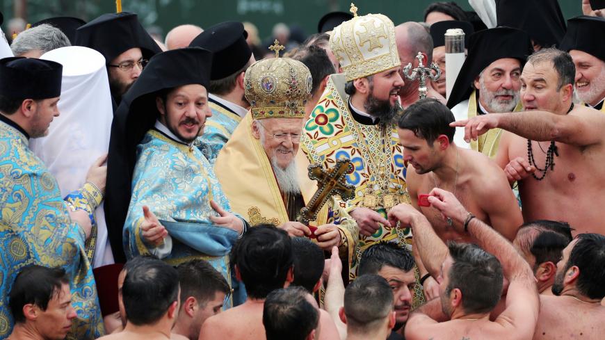 Ecumenical Patriarch Bartholomew I gives presents to Greek Orthodox faithful after they swam into the Golden Horn during the Epiphany day celebrations in Istanbul, Turkey January 6, 2019. REUTERS/Umit Bektas     TPX IMAGES OF THE DAY - RC1371622270