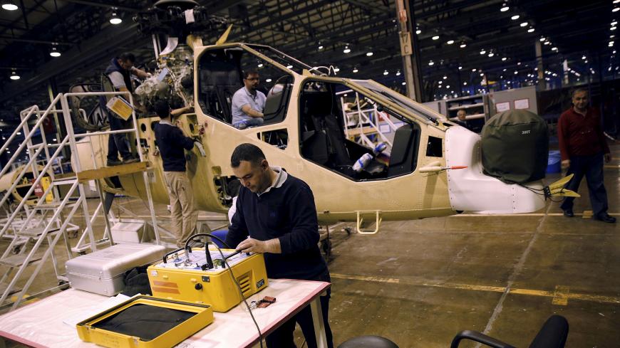 Technicians construct a Turkish Attack and Tactical Reconnaissance Helicopter (ATAK), at the Turkish Aerospace Industries Inc (TAI) factory in Ankara, Turkey, April 28, 2015. TAI, which produces F-16 fighter jets and other military aircraft, could float on the Istanbul stock exchange in the second half of this year, its chief executive told Reuters. Ankara-based TAI was established to co-produce Lockheed Martin's F-16 for the Turkish Air Force in 1984. It is almost wholly owned by the Turkish Armed Forces F