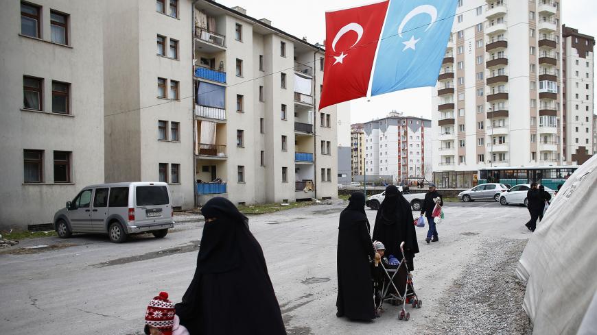 Uighur refugee women walk where they are housed in a gated complex in the central city of Kayseri, Turkey, February 11, 2015. Thousands of members of China's Turkic language-speaking Muslim ethnic minority have reached Turkey, mostly since last year, infuriating Beijing, which accuses Ankara of helping its citizens flee unlawfully. Turkish officials deny playing any direct role in assisting the flight. Picture taken February 11, 2015. To match Insight TURKEY-CHINA/UIGHURS REUTERS/Umit Bektas - GM1EB7R1LSD01