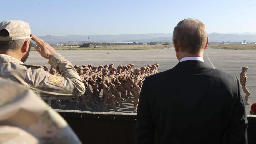 Russian President Vladimir Putin (R) and Defence Minister Sergei Shoigu watch servicemen passing by as they visit the Hmeymim air base in Latakia Province, Syria December 11, 2017.  Sputnik/Mikhail Klimentyev/Sputnik via REUTERS  ATTENTION EDITORS - THIS IMAGE WAS PROVIDED BY A THIRD PARTY. - UP1EDCB15ZA3V