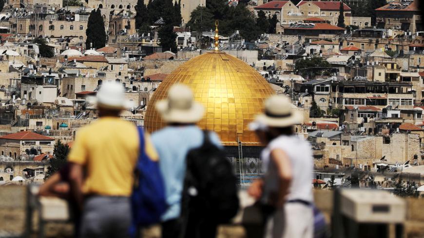 Tourists look at the Dome of the Rock, located in Jerusalem's Old City on the compound known to Muslims as Noble Sanctuary and to Jews as Temple Mount, June 21, 2018. REUTERS/Ammar Awad - RC1DA4402840