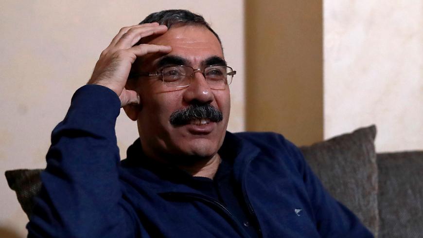 Kurdish official Aldar Khalil, who played a key role in establishing Syria's semi-autonomous Kurdish region in 2013, poses during an interview in Qamishli on December 22, 2018. - Khalil urged on December 22, 2018, the United States to stop Turkey launching an offensive against Kurdish areas in northern Syria, after Washington announced the withdrawal of American troops. Washington has for years supported the Kurdish-led Syrian Democratic Forces (SDF) in the fight against the Islamic State group in Syria, as