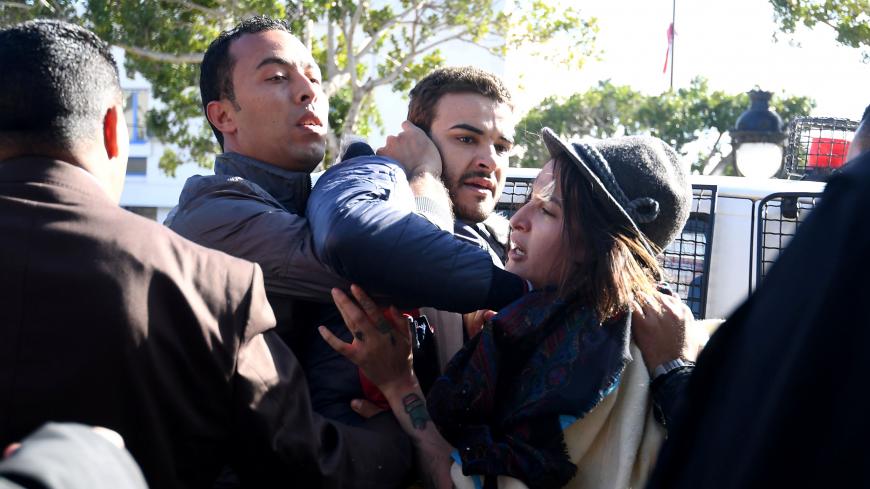 Policemen in plain clothes force LGBT activists Radio Shams host, Fares Hadj Amor (C) and Femen's Amina Sboui into a vehicle as they disperse a protest in Tunis on January 27, 2018.
A call had been made to protest outside the tourism ministry under the hashtag "#Sayebni" ("Let me go") to demand the repeal of "retrograde" laws and the end of "the criminalisation of sexual freedom and discrimination against women". / AFP PHOTO / FETHI BELAID        (Photo credit should read FETHI BELAID/AFP/Getty Images)