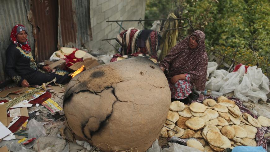 Palestinian women bake bread in a clay oven in the northern Gaza Strip May 5, 2014. REUTERS/Mohammed Salem (GAZA - Tags: SOCIETY) - GM1EA5607K501