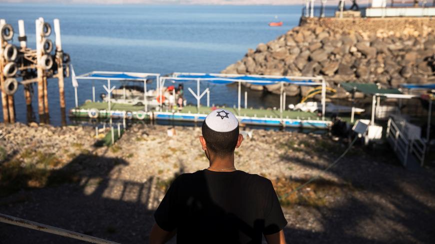 A youth wearing a yarmulke with a Star of David looks towards a temporary pier at the Sea of Galilee in northern Israel November 1, 2018. Picture taken November 1, 2018. REUTERS/Ronen Zvulun - RC19DCD86960