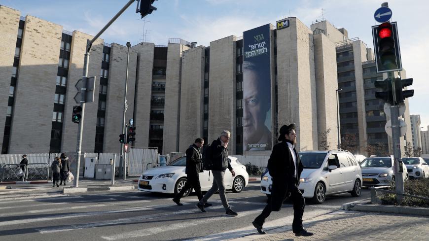 People walk past a campaign poster of Benny Gantz, a former Israeli armed forces chief and the head of a new political party, Israel Resilience, in Jerusalem, January 29, 2019  REUTERS/Ammar Awad - RC16AFABDBD0