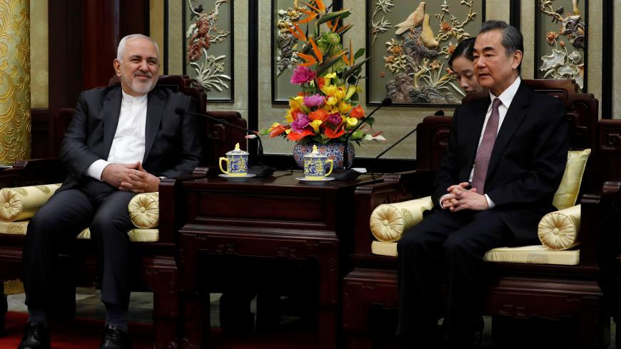 Iranian Foreign Minister Mohammad Javad Zarif (L) and his Chinese counterpart Wang Yi chat during their meeting at the Diaoyutai State Guesthouse in Beijing, China February 19, 2019. How Hwee Young/Pool via REUTERS - RC181062C080