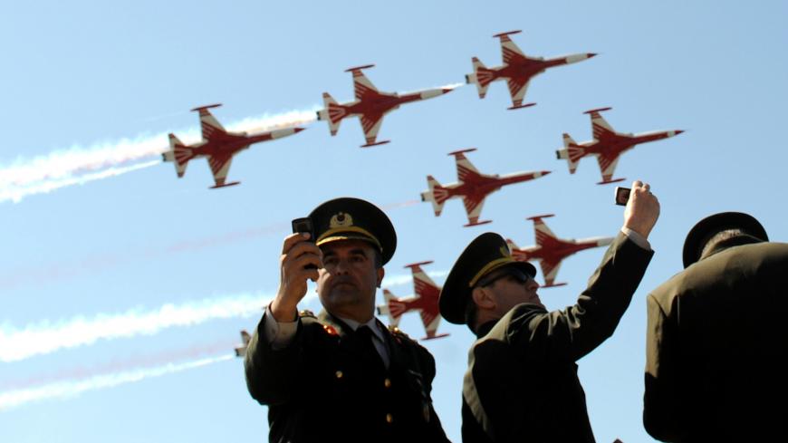 Turkish air force patrollers fly by as Turkish soldiers take photos with their mobile phones during a ceremony celebrating the 96th anniversary of Anzac Day in Canakkale on April 24, 2011. A dawn ceremony on April 25 marks the time of the first landings of the Australian and New Zealand Army Corps (ANZAC) at the Gallipoli peninsula in the ill-fated Allied campaign to take the Dardanelles Strait from the Ottoman Empire. In the ensuing eight months of fighting, about 11,500 ANZAC troops were killed, fighting 
