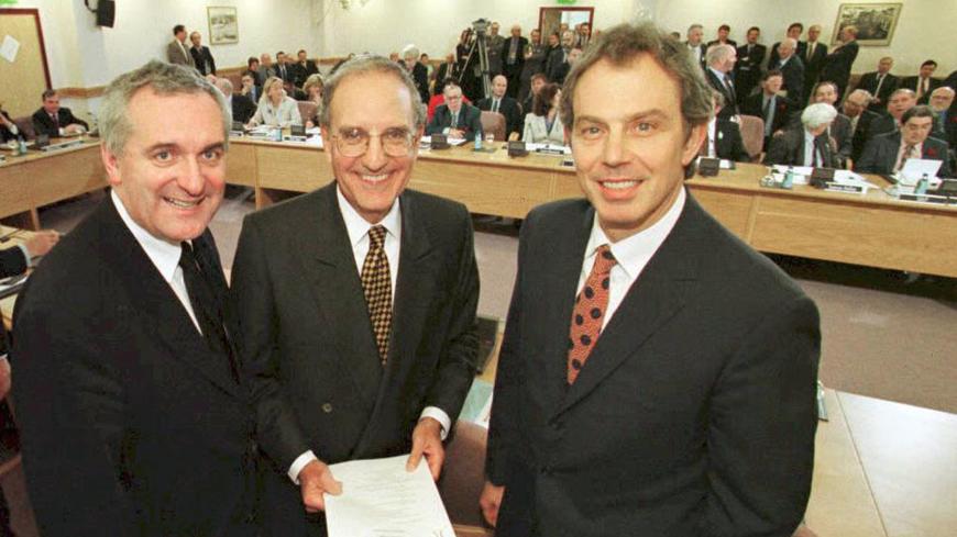 (FILES) File picture of  British Prime Minister Tony Blair (R), US Senator George Mitchell (C) and Irish Prime Minister Bertie Ahern (L) smiling on April 10, 1998, after they signed an historic agreement for peace in Northern Ireland, ending a 30-year conflict. The Good Friday Agreement signed 10 years ago, was approved by a referendum. The agreement was promoted to the nationalist community as delivering civil rights, inclusive government, recognition of their Irishness, and a peaceful route to Irish reuni