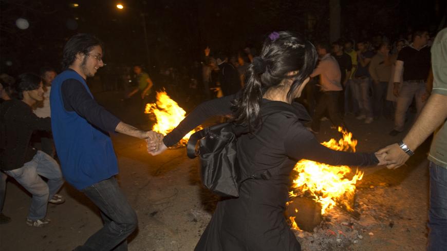 A woman dances with men during the "Chaharshanbeh Soori" festival in Tehran March 18, 2008. People jump over fire during the festival to burn away the year's sins on the last Tuesday night before the new year. REUTERS/Raheb Homavandi (IRAN) - GM1E43J07KQ01