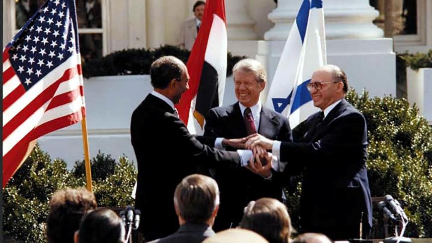 FILE PHOTO: U.S. President Jimmy Carter, Egyptian President Anwar Sadat and Israeli Prime Minister Menachem Begin join hands in celebration of the signing of the ÒTreaty of Peace Between the Arab Republic of Egypt and the State of IsraelÓ at the White House in Washington, D.C., March 26, 1979. Courtesy Jimmy Carter Library/National Archives/Handout via REUTERS/File Photo  ATTENTION EDITORS - THIS IMAGE WAS PROVIDED BY A THIRD PARTY.  PLEASE SEARCH "FROM THE FILES - 40TH ANNIVERSARY OF EGYPT-ISRAEL PEACE TRE