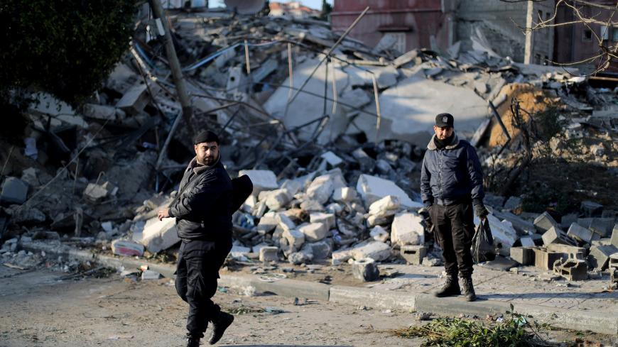 Palestinian policemen loyal to Hamas stand guard at the site of a Hamas-run insurance office after it was destroyed by an Israeli air strike in Gaza City March 26, 2019. REUTERS/Mohammed Salem - RC1FD529B5A0