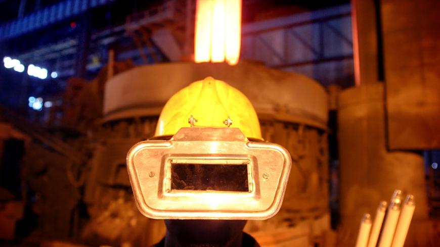An Iranian worker wears a protection hat at the Steel Saba Complex in Isfahan province 451 km south of Tehran August 12, 2004. REUTERS/Stringer/File Photo - S1BEUCXGRUAA