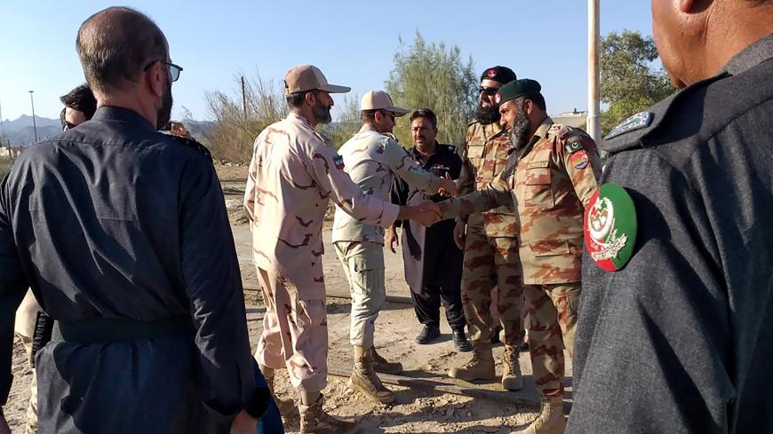 In this picture taken on April 21, 2019, Pakistani border security officials (R) and Iranian border security officials (L) shake hand each others at Zero Point in the Pakistan-Iran border town of Taftan. - Iran and Pakistan have agreed to set up a joint border "reaction force" following a number of deadly attacks by militant groups on their frontier, Iranian President Hassan Rouhani announced April 22 after talks with visiting Pakistani Prime Minister Imran Khan. (Photo by STR / AFP)        (Photo credit sh