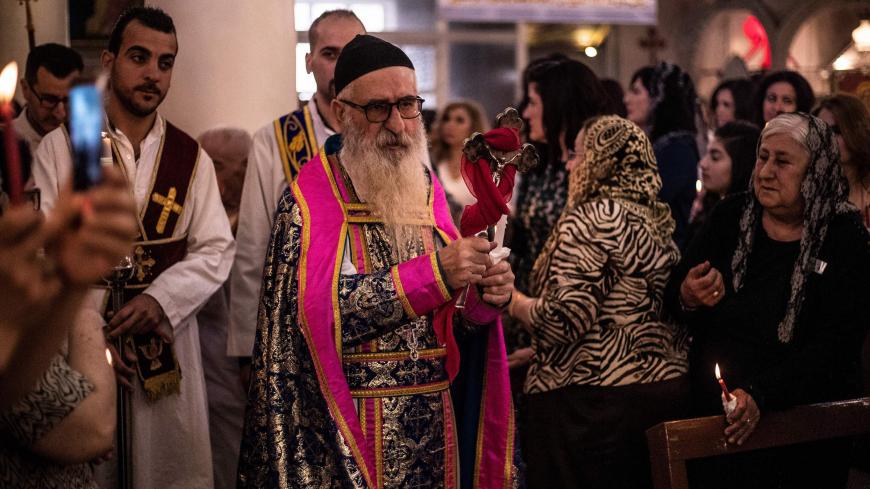 A priest blesses worshippers during an Orthodox Easter service at the Church of Saint Jacob in the Kurdish-controlled city of Qamishli in northeastern Syria on April 28, 2019. (Photo by Delil souleiman / AFP)        (Photo credit should read DELIL SOULEIMAN/AFP/Getty Images)