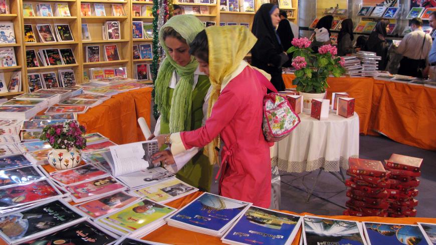 TEHRAN, IRAN - MAY 4, 2008: A young girl and her mother in colourful veils look at books in a hall, at the 21st Tehran International Book Fair on the city's congregational prayer site on May 4, 2008 in Tehran, Iran. The annual event showcases 200,000 titles from 1700 domestic and 840 international publishers from 75 countries. The books will be presented under categories for General, Academic, Educational and Children's books. (Photo by Kaveh Kazemi/Getty Images)