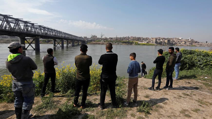 Iraqi people gather near the site where a ferry sank in the Tigris River in Mosul, Iraq March 23, 2019. REUTERS/Khalid al-Mousily - RC14D3C6A920